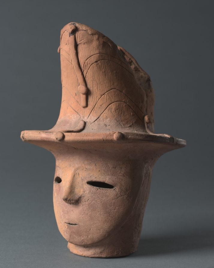 Haniwa de războinic, secolele V–VI: platoșă din plăci legate cu sfoară, coif, față plată cu găuri pentru ochi. Figurile erau așezate la suprafață, pe…